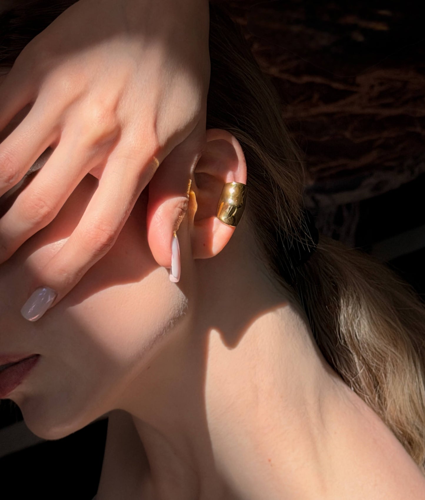 Model wearing molten gold ear cuff