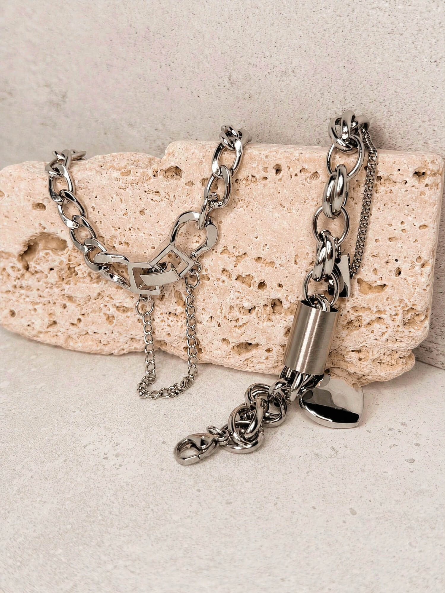 Silver chain bracelet with toggle clasp and heart charm bracelet styled on stone