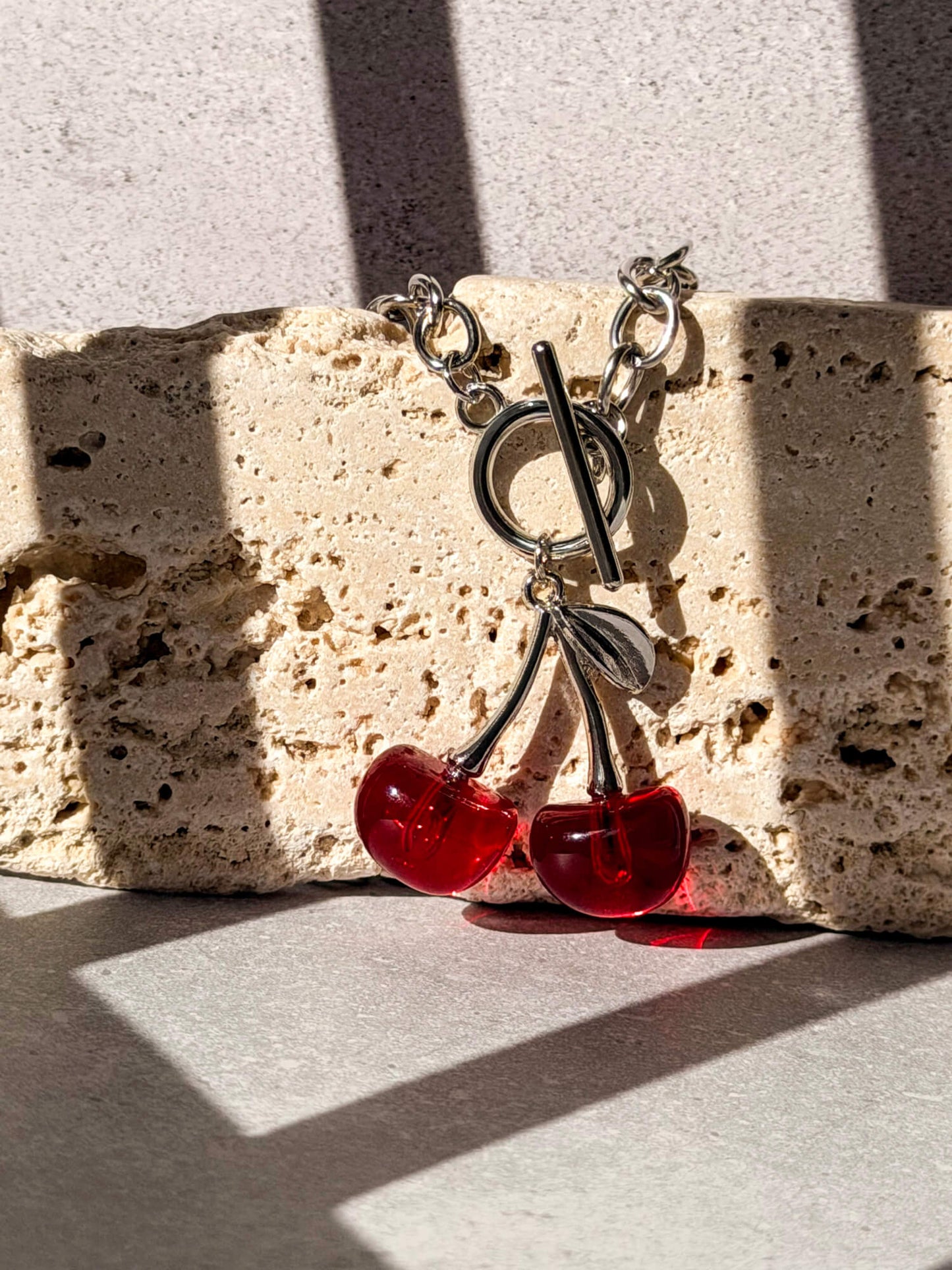 Silver curb chain necklace, cherry pendant detail