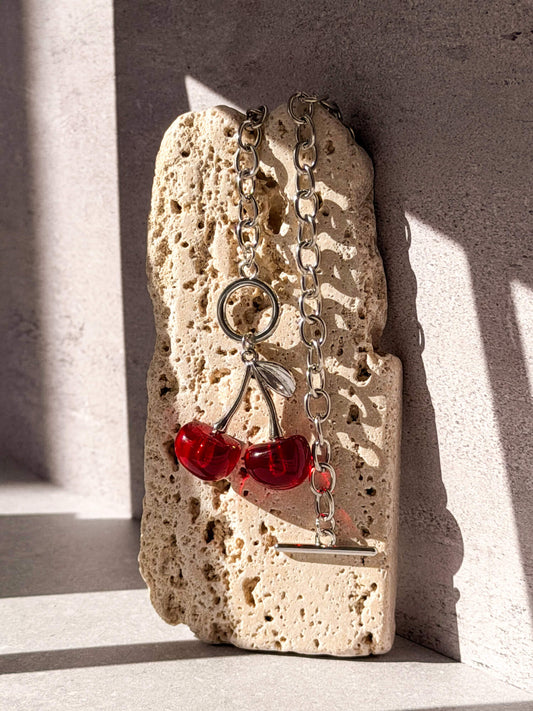 Red enamel cherry charm detail on silver necklace