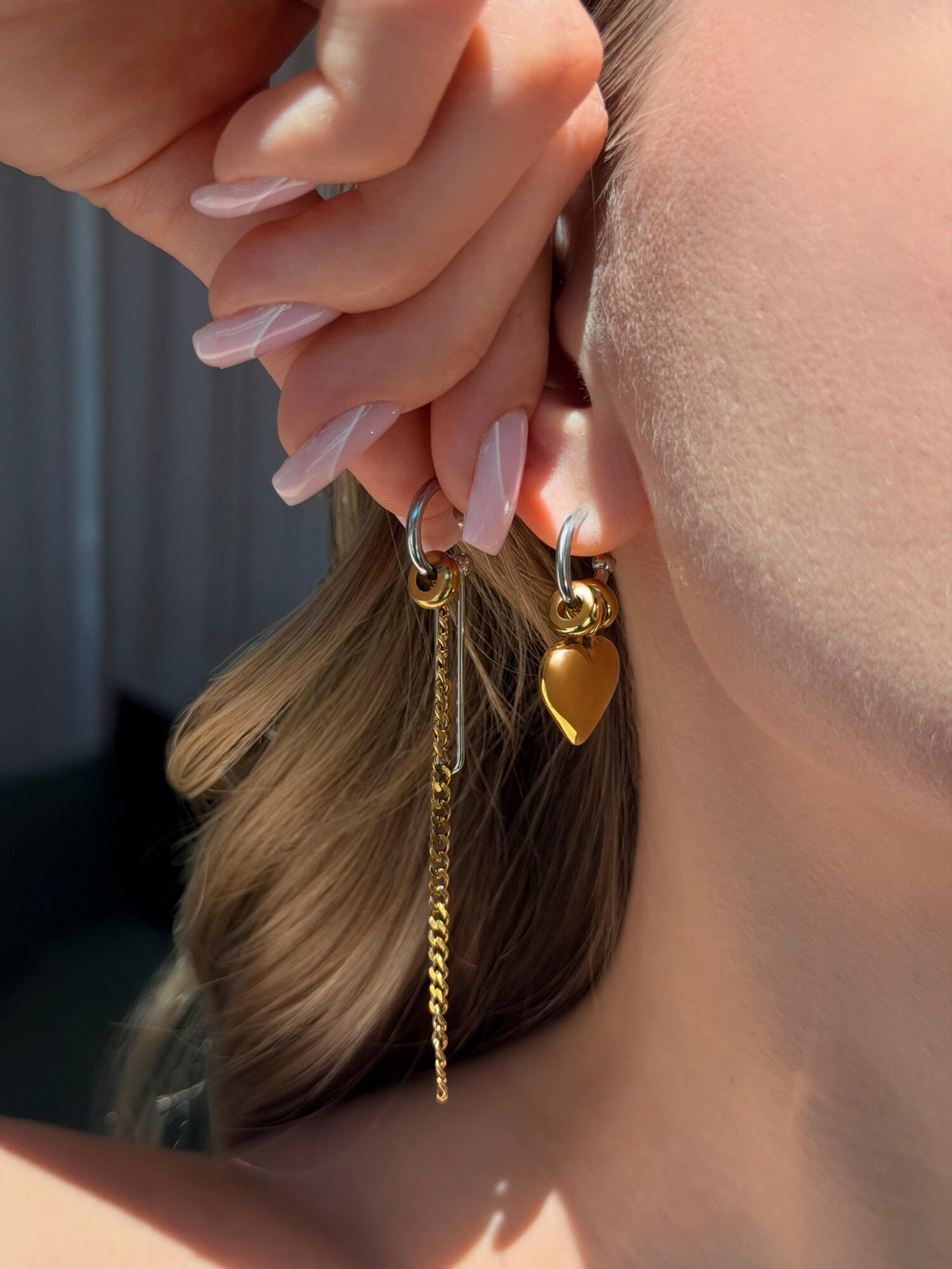 Model showing convertible chain and heart earrings