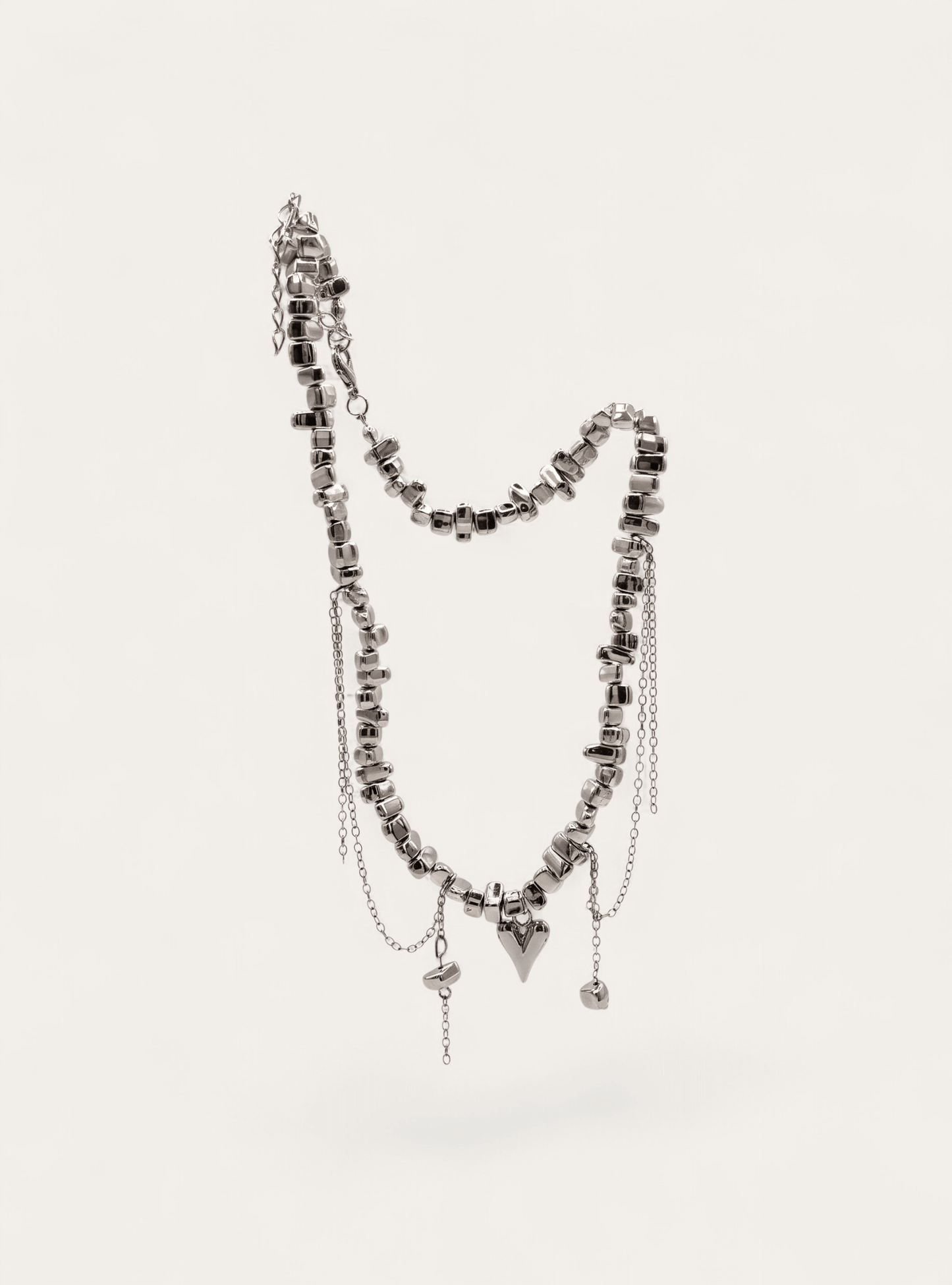 Silver beaded necklace with draped chain and charm details