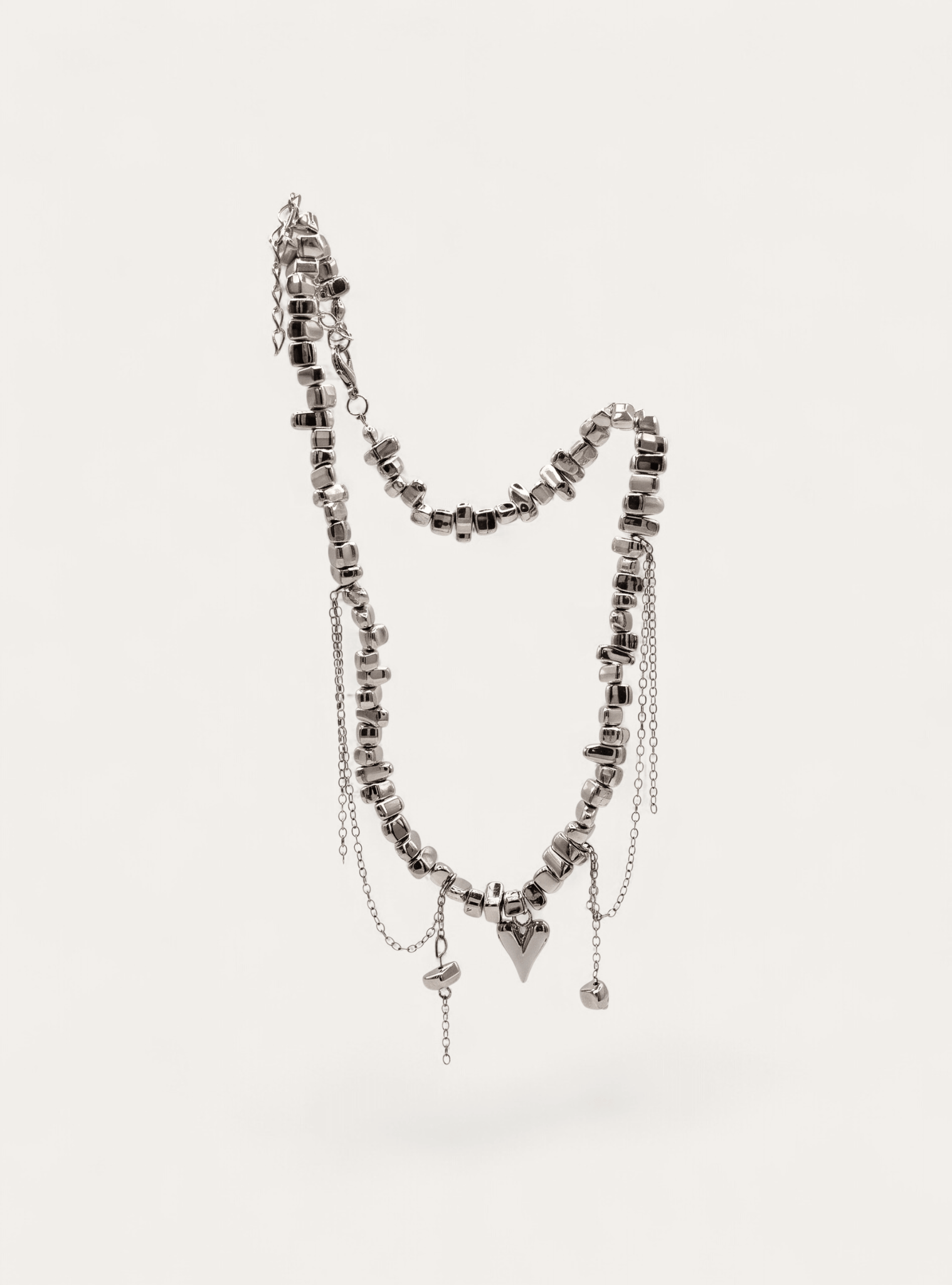 Silver beaded necklace with draped chain and charm details