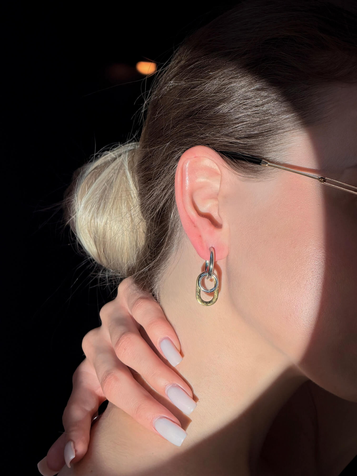 Model wearing dual link two-tone earrings