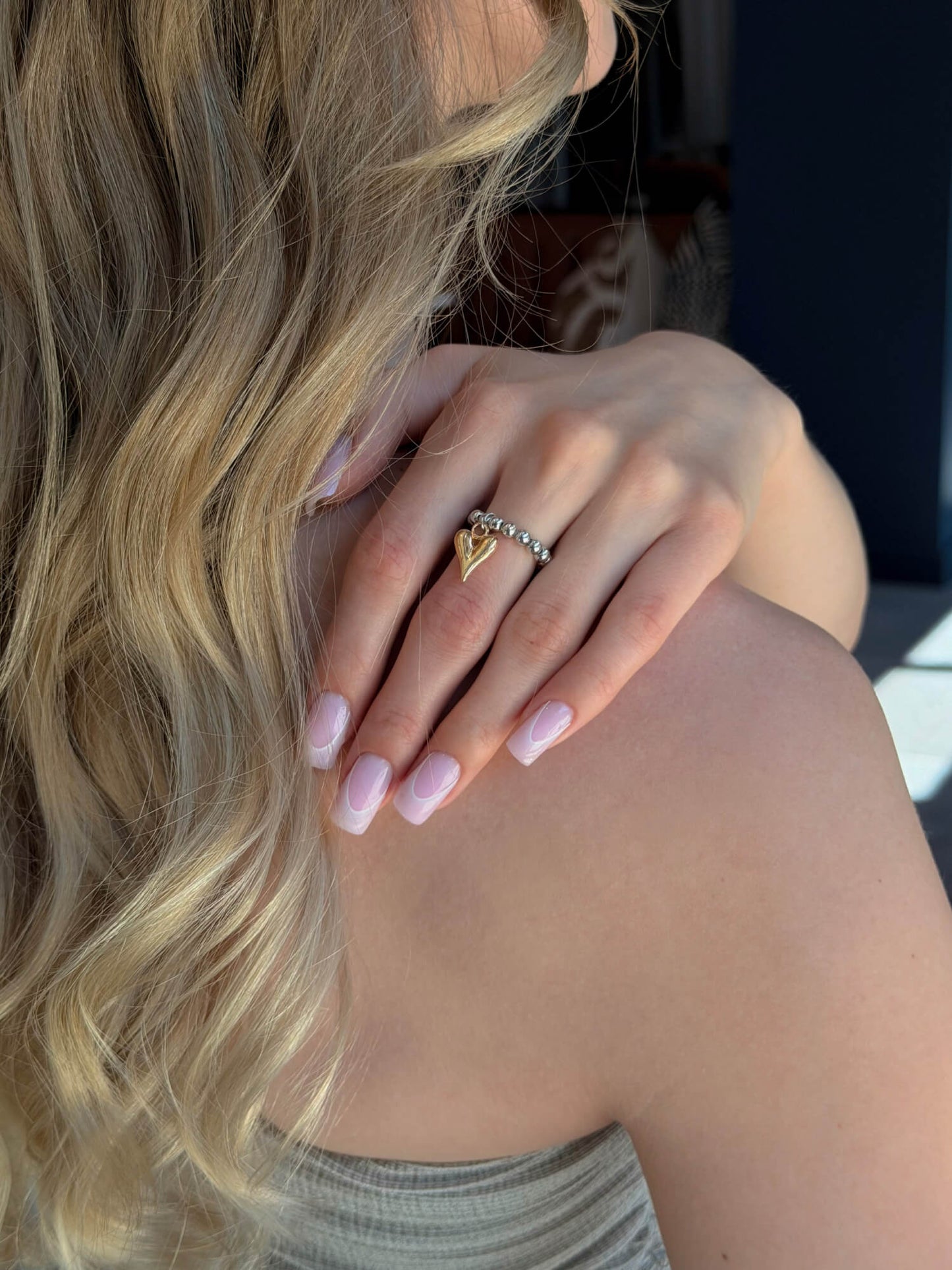 Model wearing heart charm beaded ring on finger