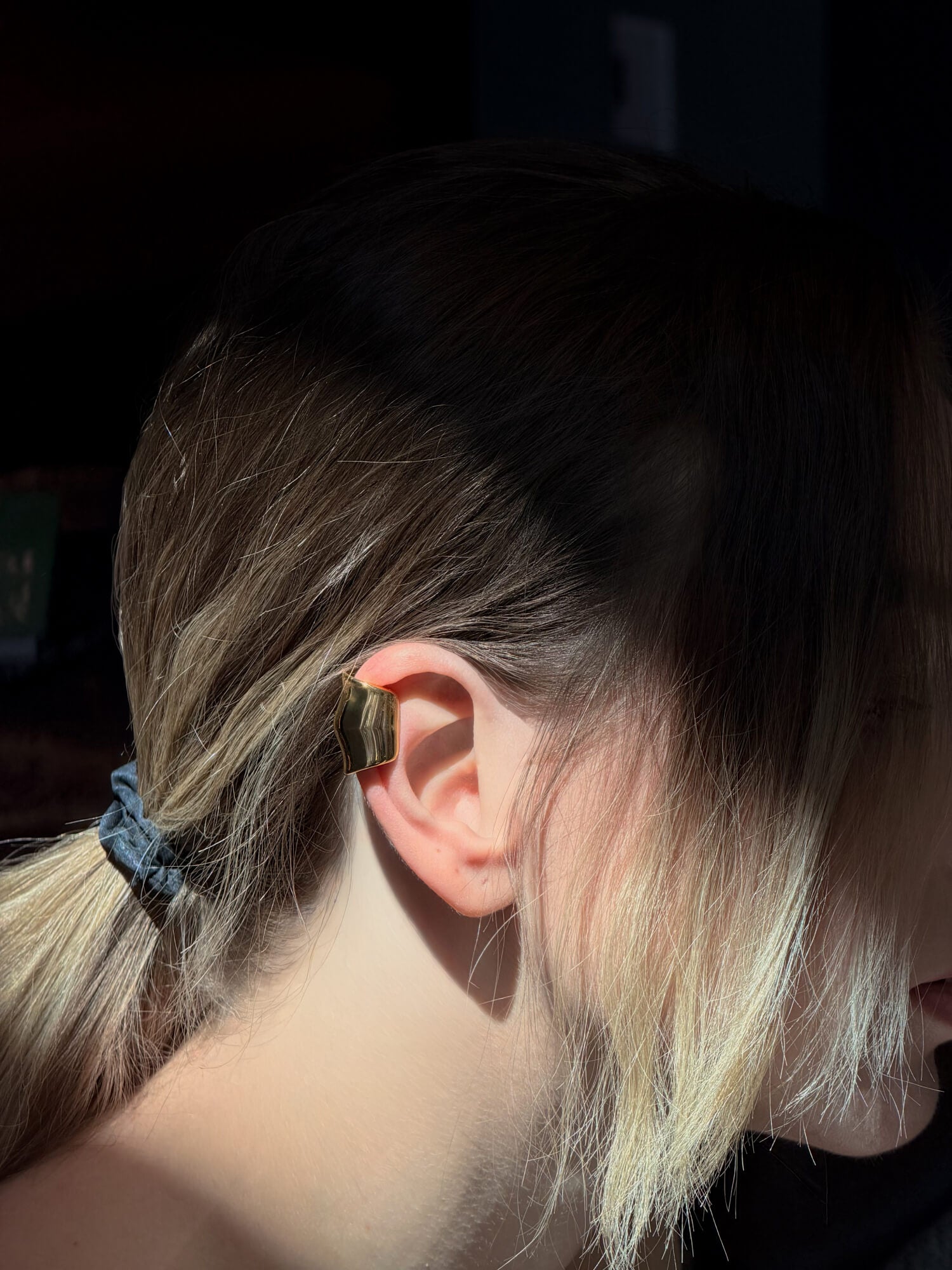 Model wearing molten gold ear cuff