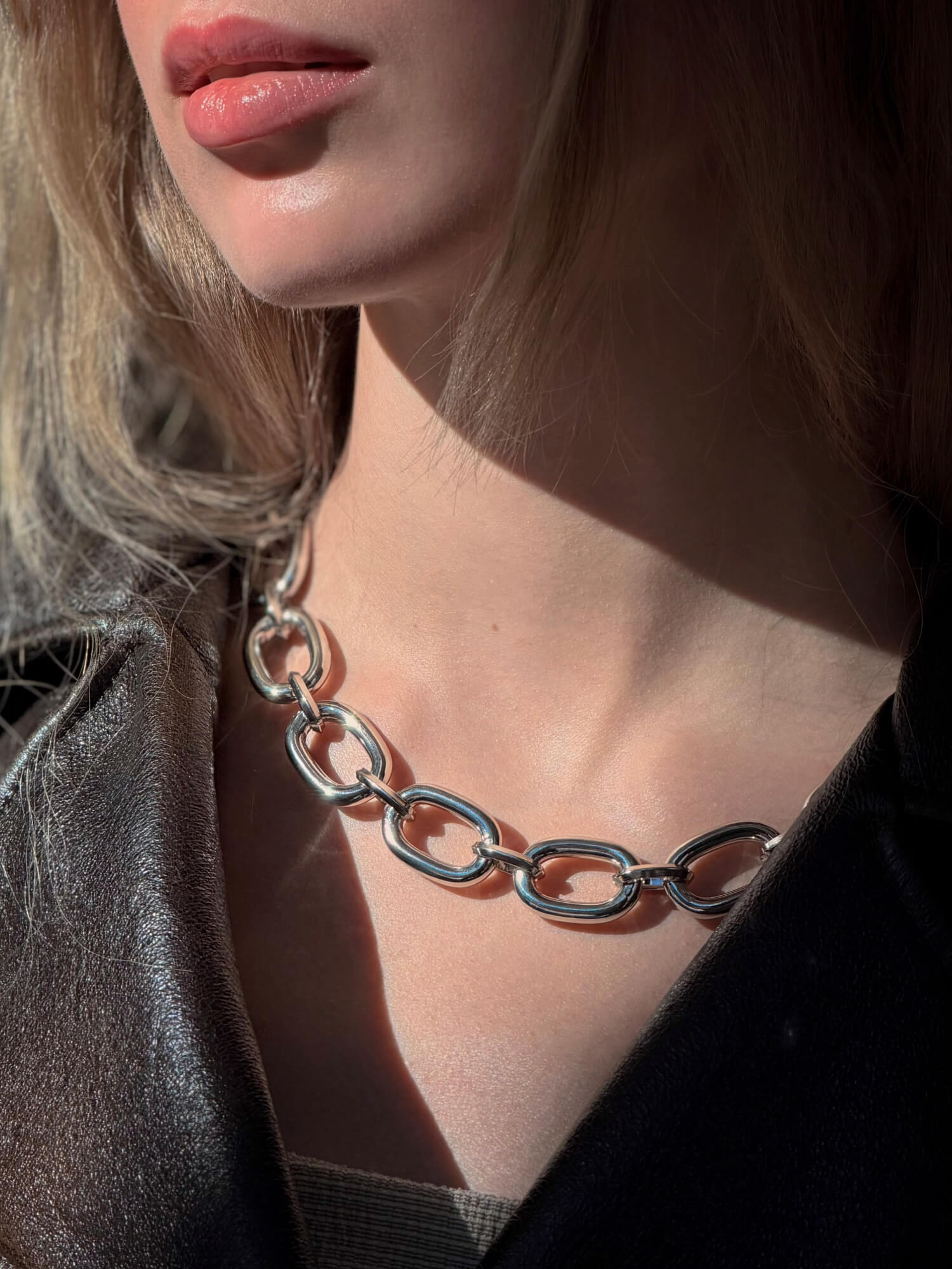 Model wearing sculptural silver chain necklace