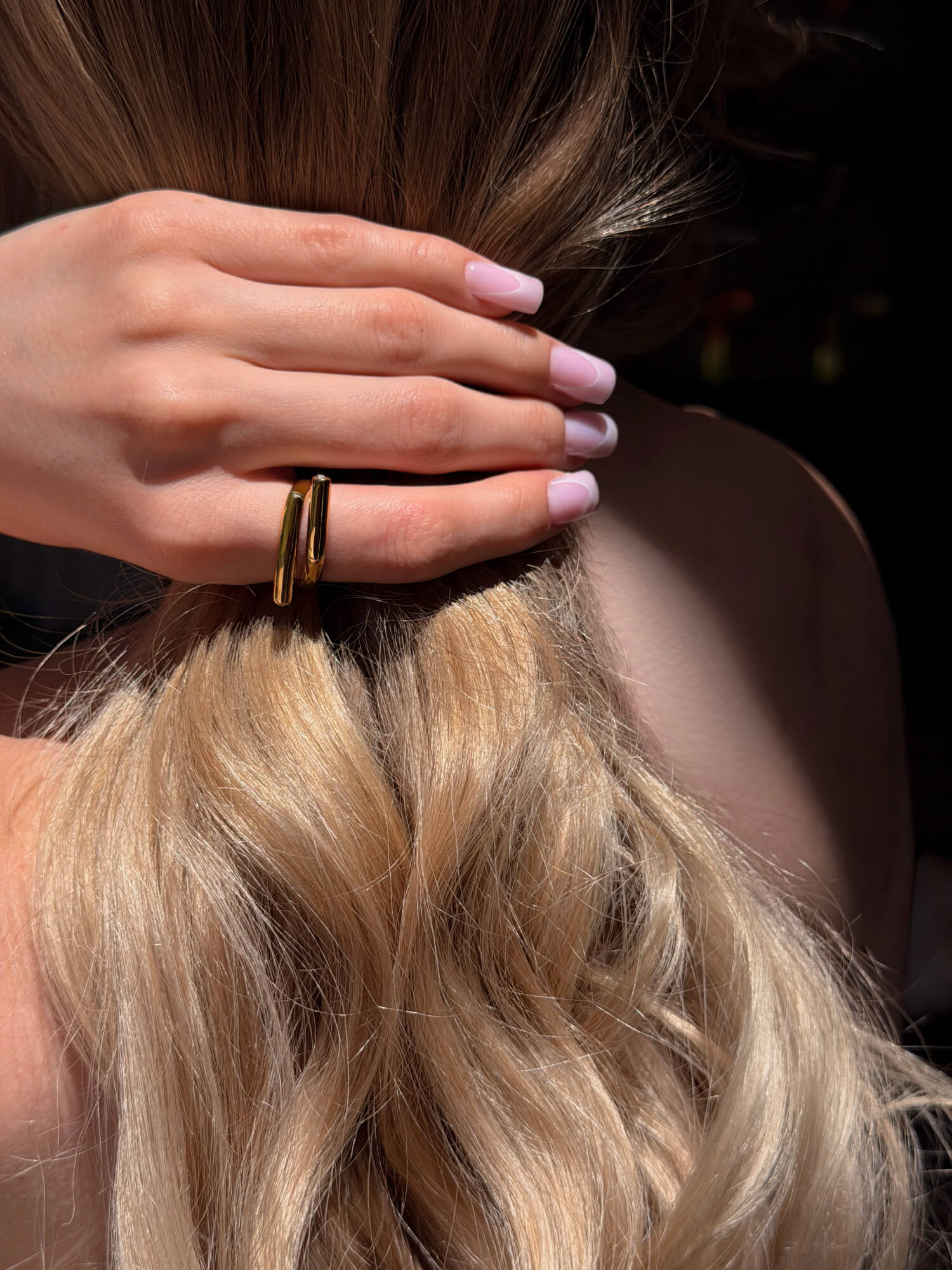 Model wearing sculptural wrap gold ring on finger